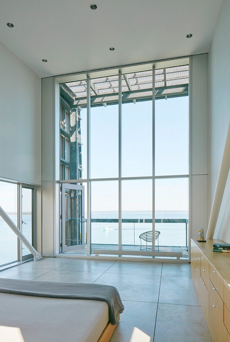 High-ceilinged room with panoramic window and sea view