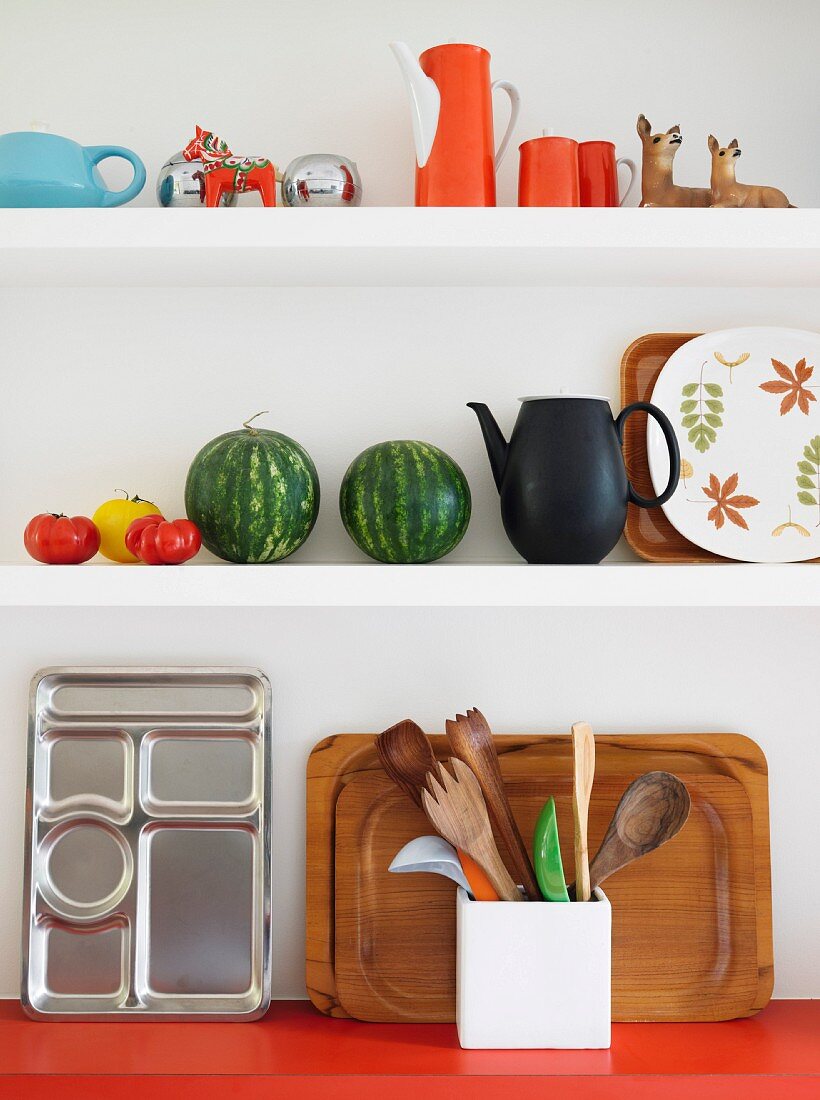 weiße Küchenboards mit farbigem Retro Geschirr, Wassermelonen und Tabletts