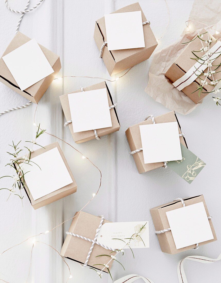 Kleine Papierschachteln mit weißen Kärtchen und Geschenkband