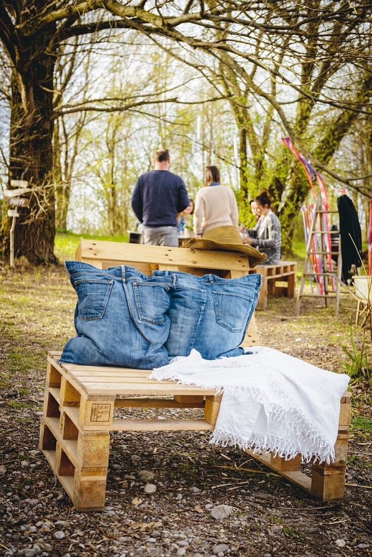 Palettenmöbel mit Kissenbezügen aus ausrangierten Jeans im Garten