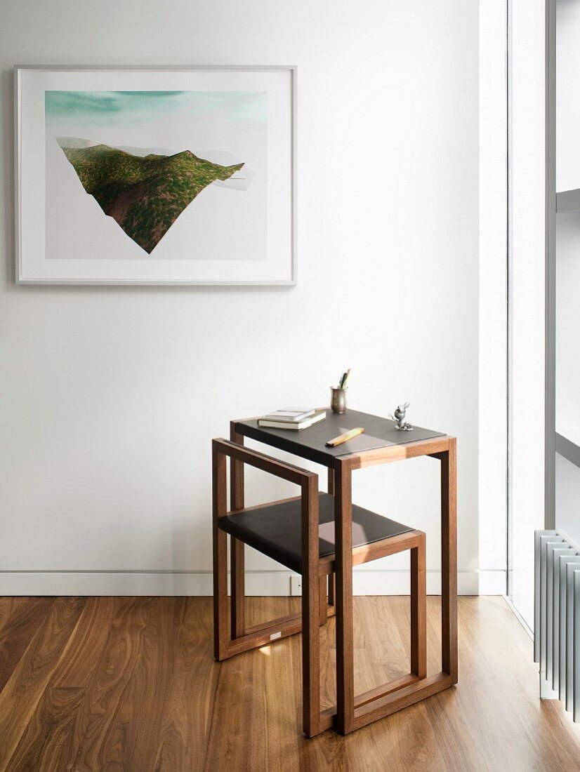 Edler, minimalistischer Schreibtischplatz vor Fenster und gerahmter moderner Kunst