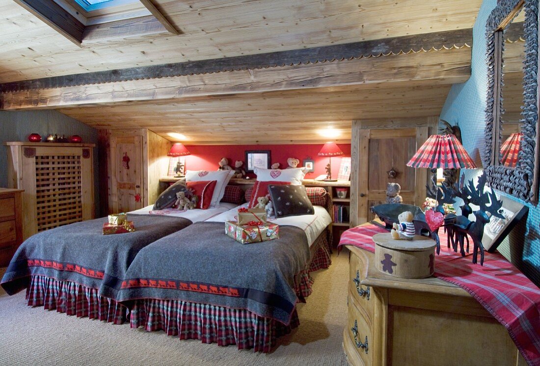 Lit table lamps and Christmas presents in cosy chalet bedroom