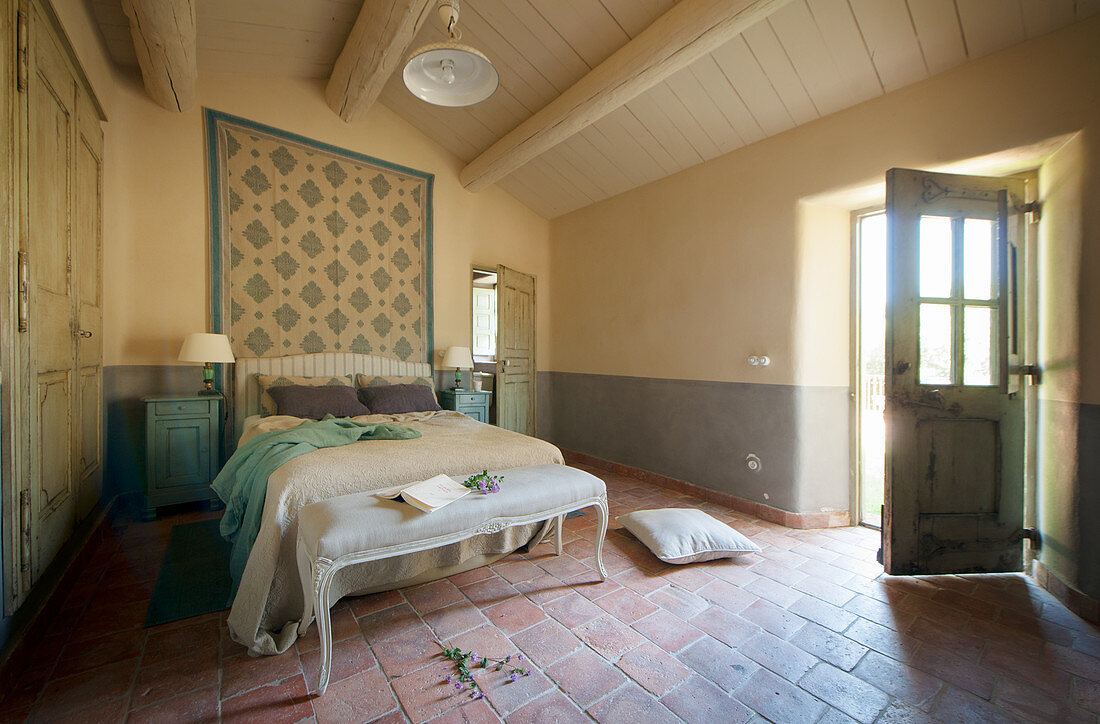 Offene Tür ins mediterrane Schlafzimmer mit Terracottafliesenboden