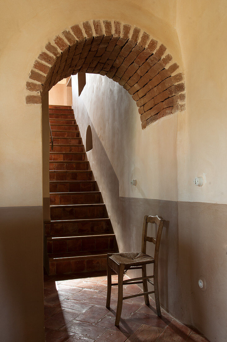 Chair under arch at foot of staircase