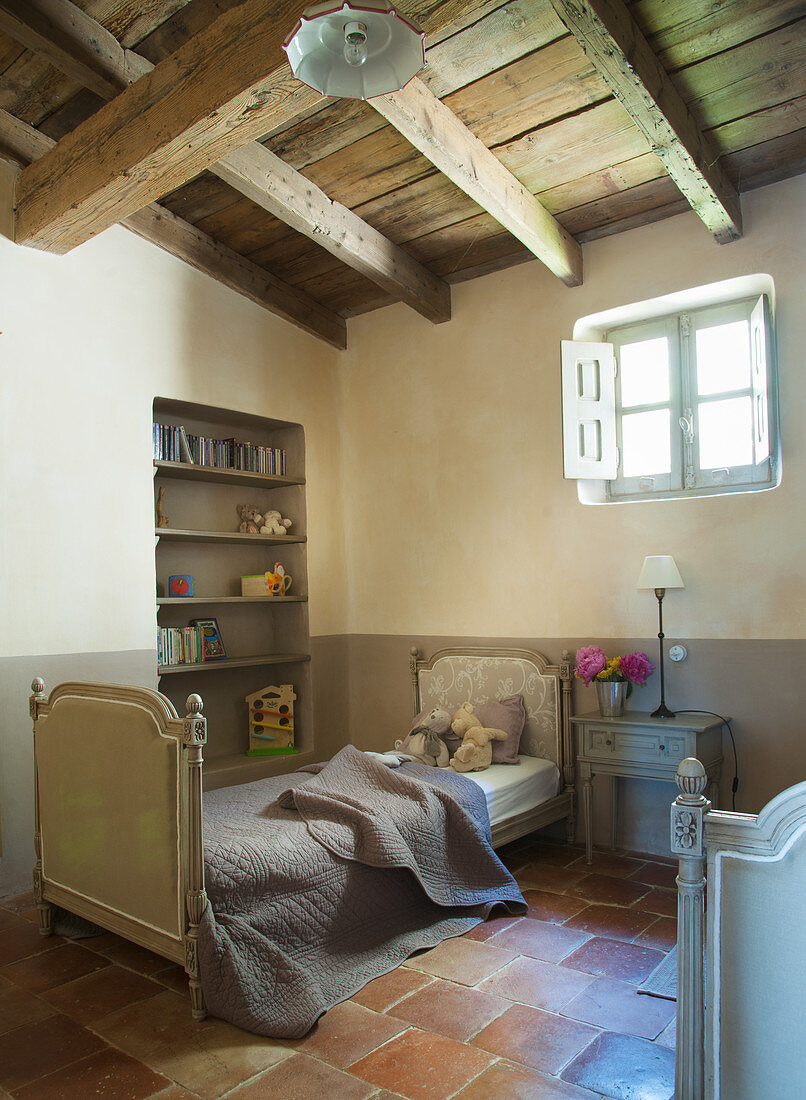 Wood-beamed ceiling in French-style child's bedroom