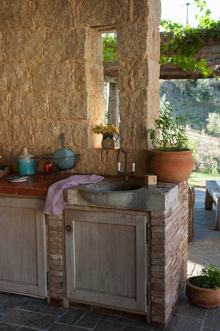 Gemauerte Außenküche mit Steinwaschbecken auf der Terrasse