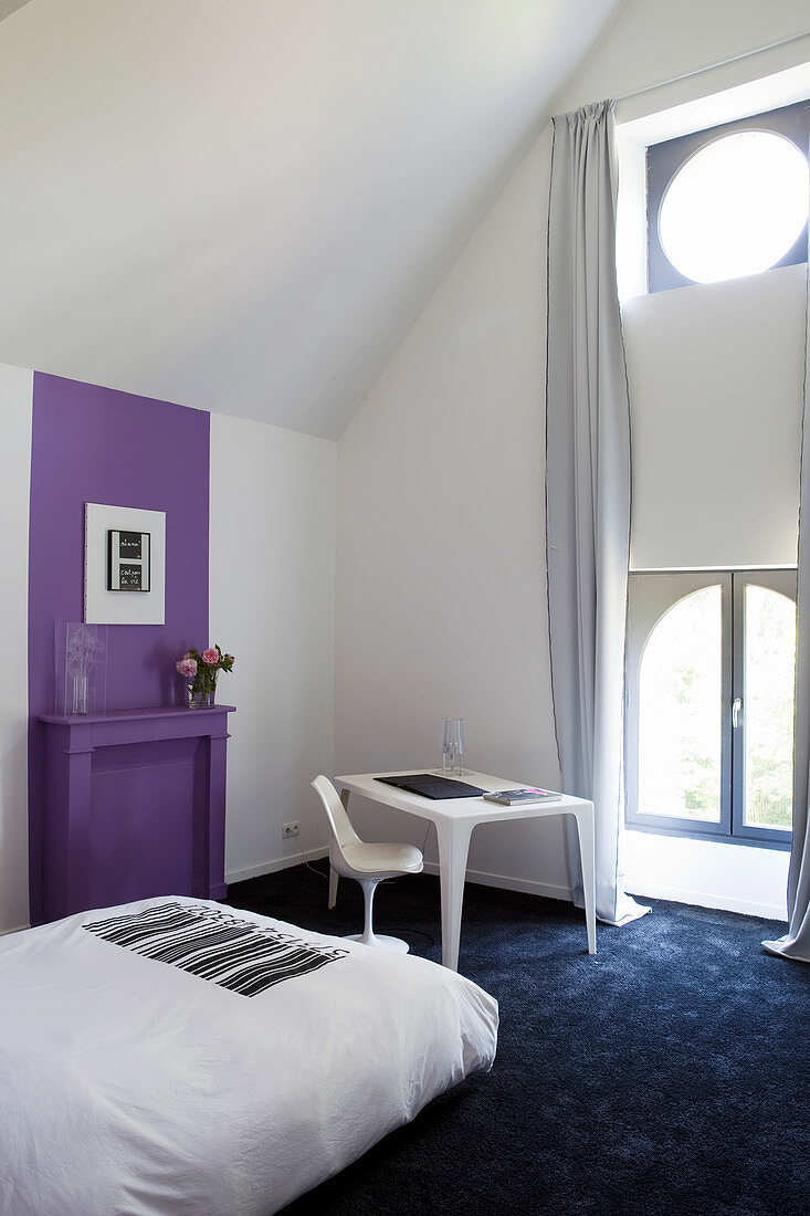 Künstlerisches Schlafzimmer mit violettem Farbakzent an der Wand