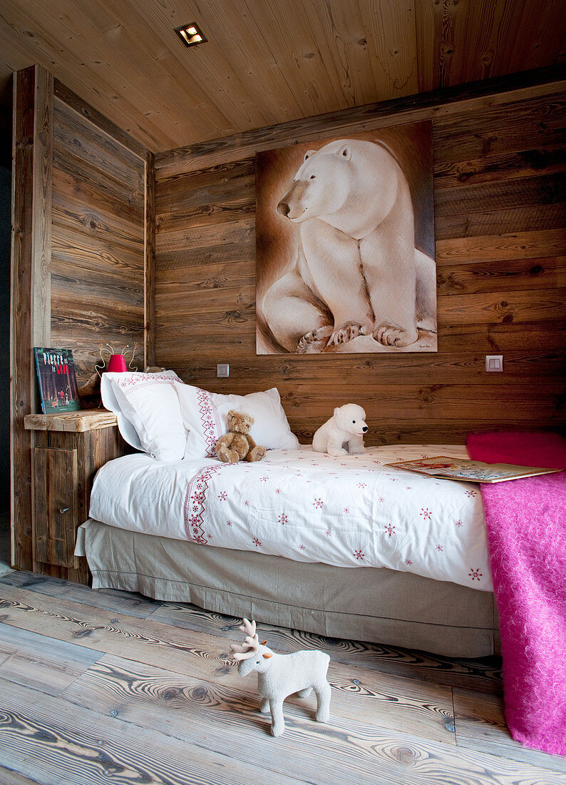 Eisbär-Bild über dem Bett im Kinderzimmer mit Holzwänden