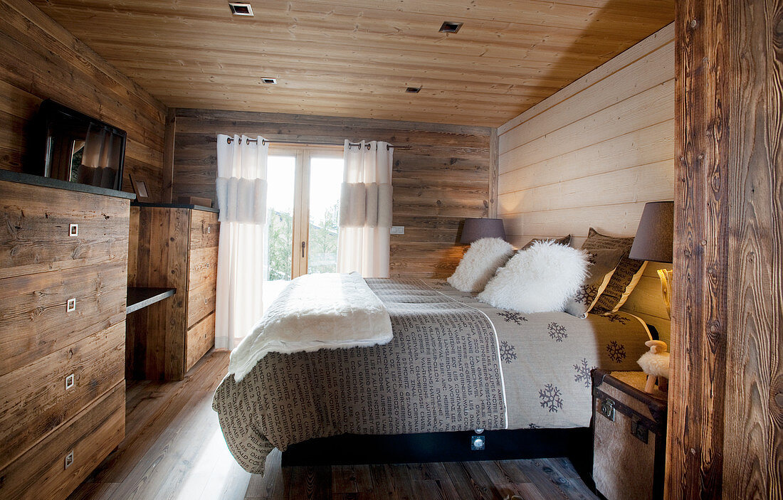Rustic bedroom with wood panelling and log-cabin ambiance