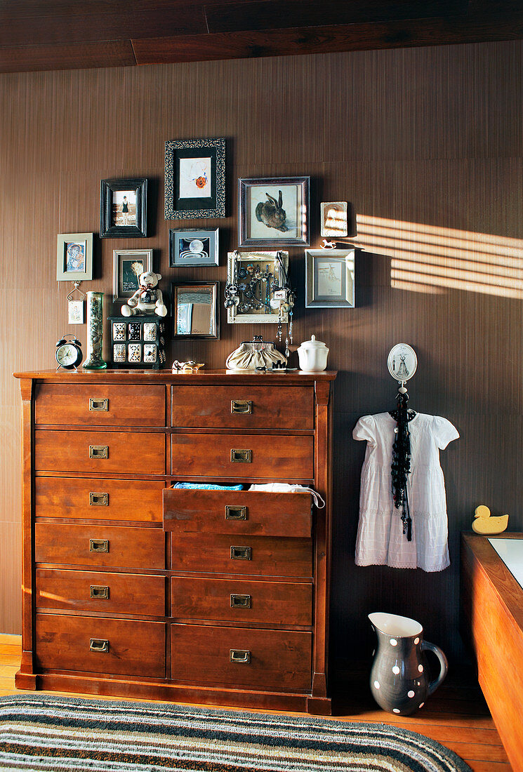 Gallery of pictures above wooden chest of drawers