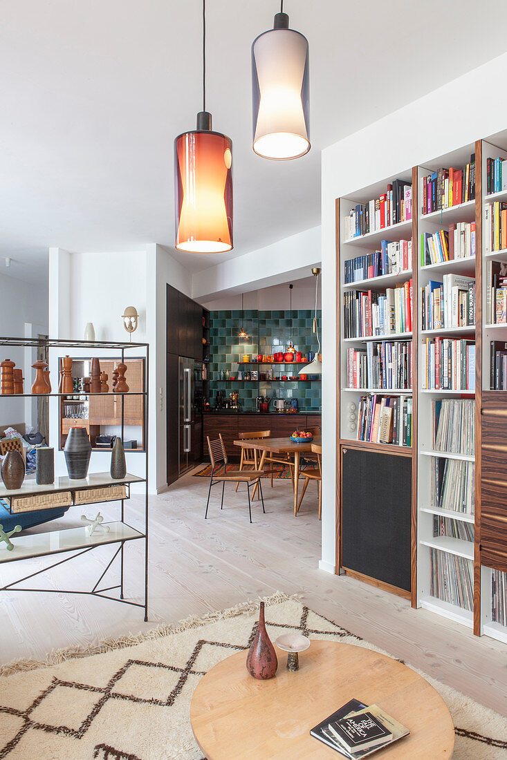 Blick vom Wohnzimmer mit Bücherwand in die offene Küche