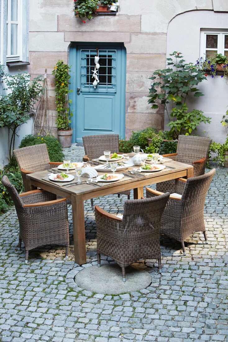 Set table in courtyard in front of blue front door