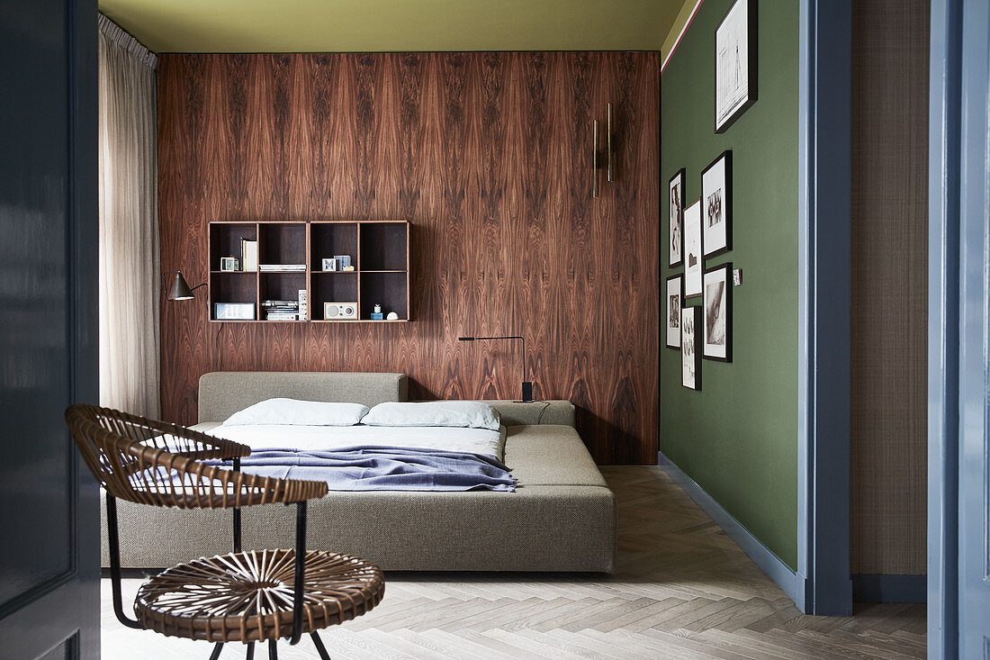 Wand mit Holzverkleidung und grüne Wand mit Bildern im Schlafzimmer