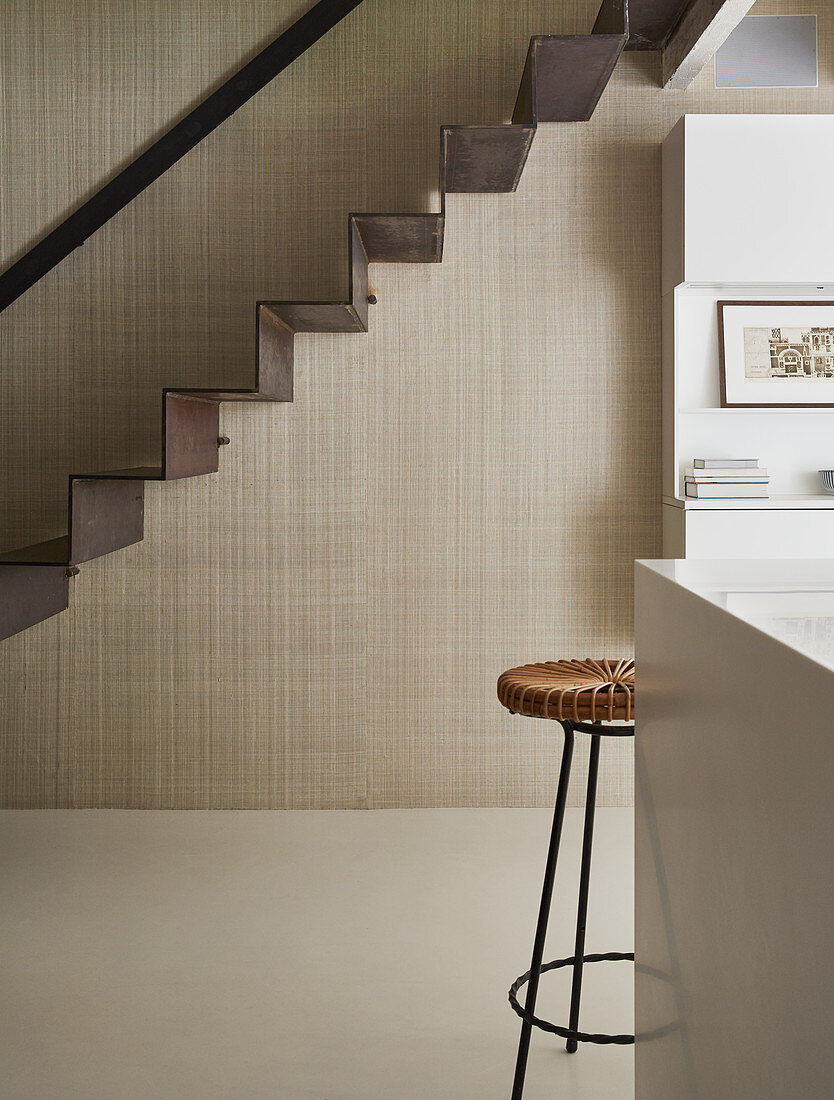 Self-supporting staircase made from a single piece of metal against beige wall