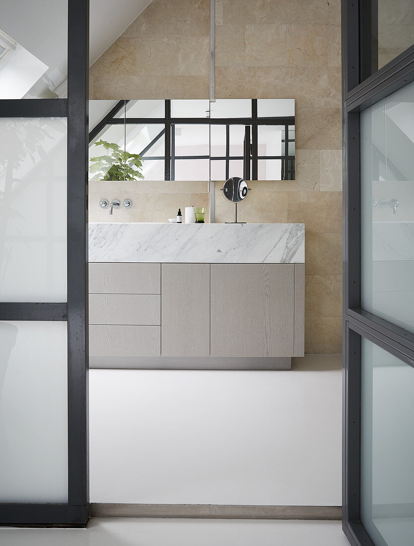 View through open glass door into modern bath with simple, clean lines