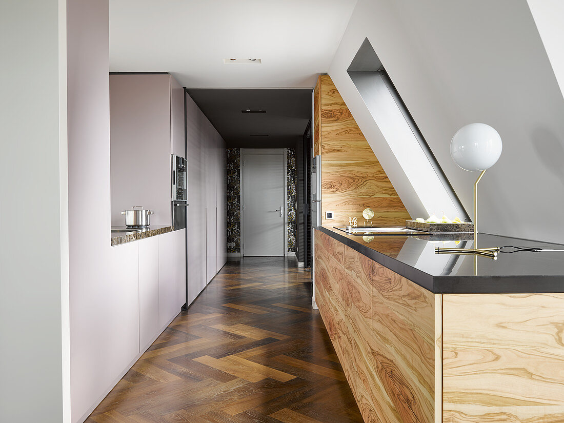 Minimalist kitchen with wooden fronts under sloping ceiling