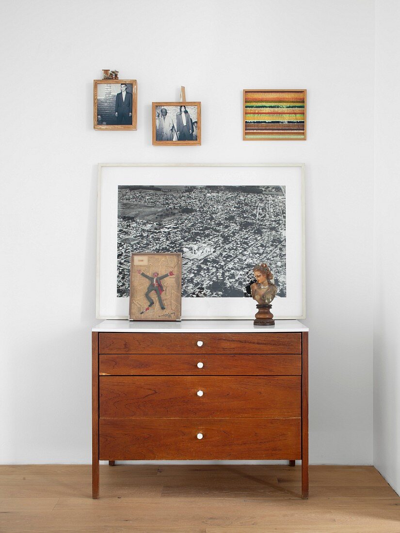 Artwork on top of vintage chest of drawer in bedroom