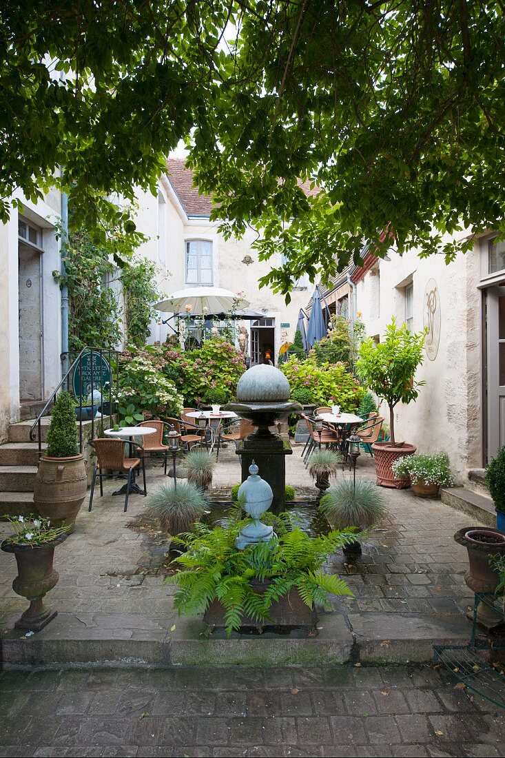 Café im bepflanzten Innenhof im mediterranen Stil