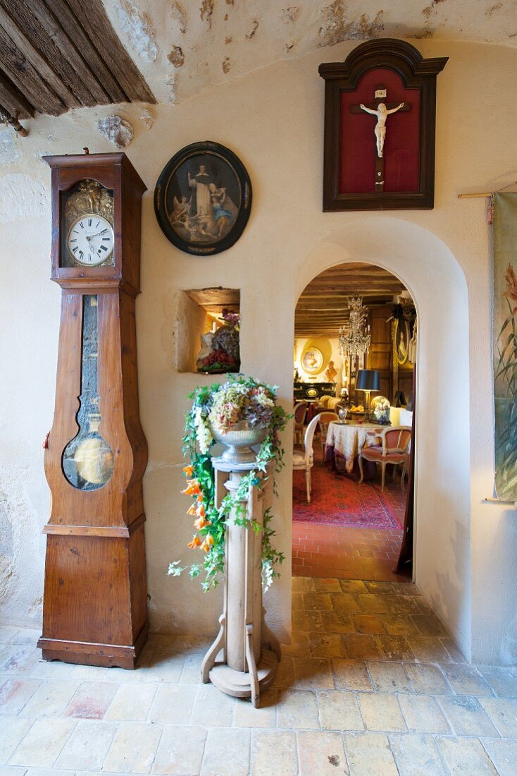 Antique long-case clock in foyer with view into cafe