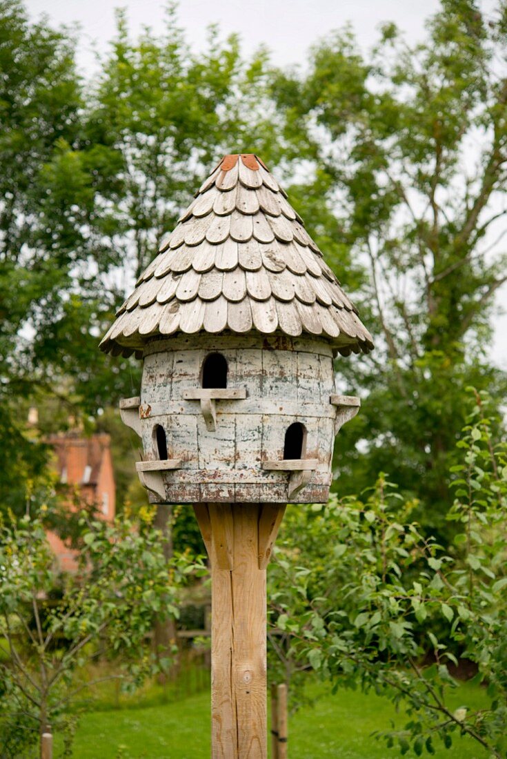 Vintage dovecot with shingle roof in garden