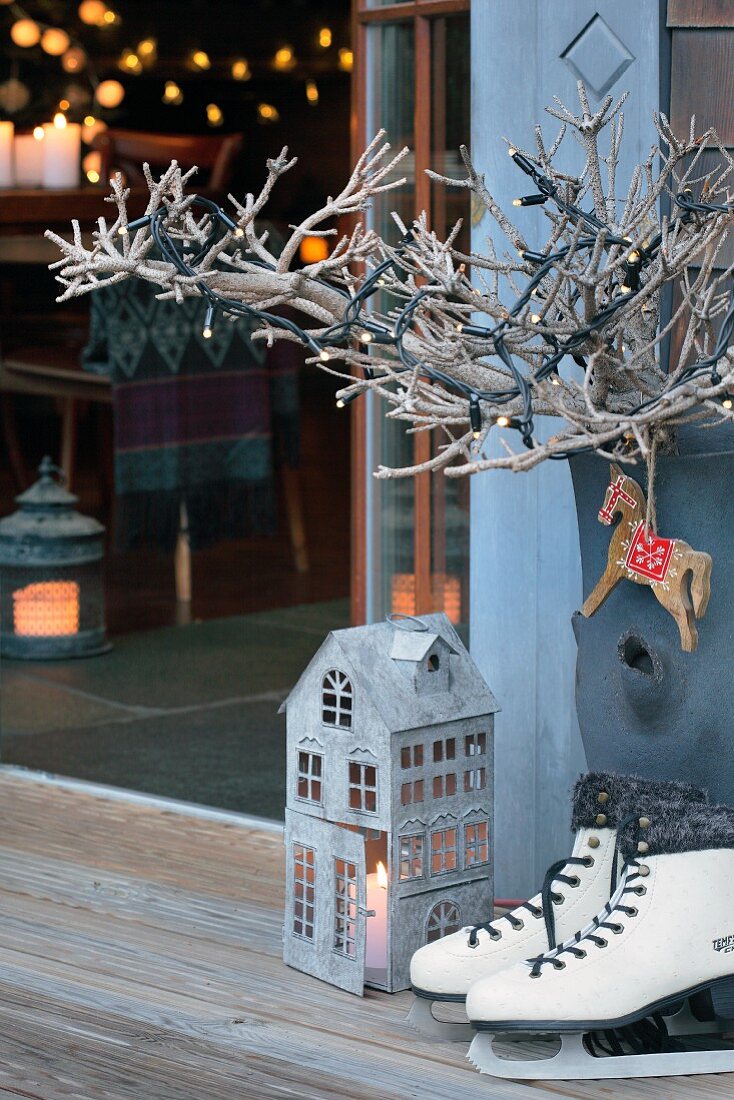 Ice-skates, lantern and branch of fairy lights
