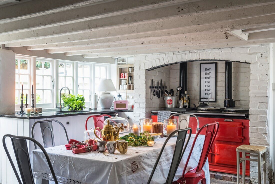 Roter Küchenherd und weihnachtlich dekorierter Esstisch