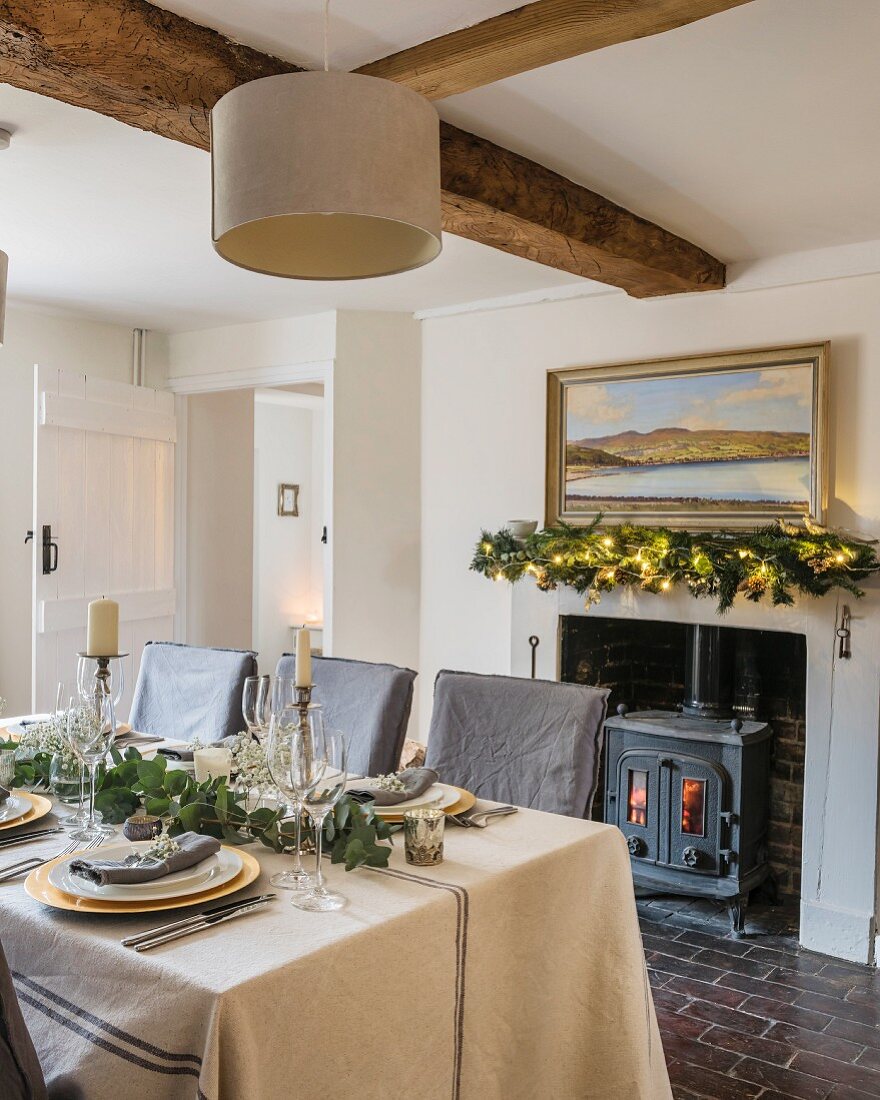 Festively set table in cottage with wooden beams and stone floor