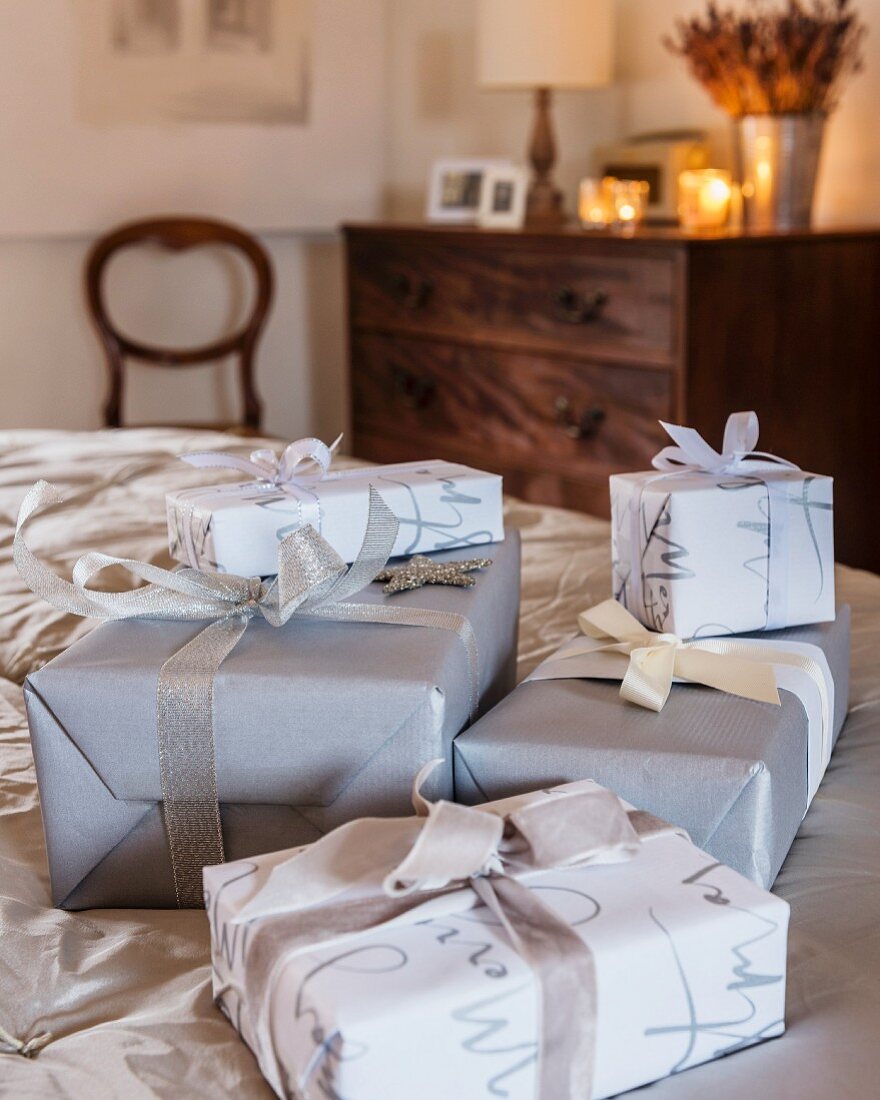 Verpackte Geschenke in Grau, Silber und Weiß im Schlafzimmer