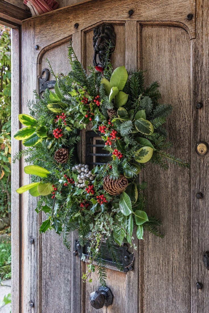Festive wreath on rustic wooden front door