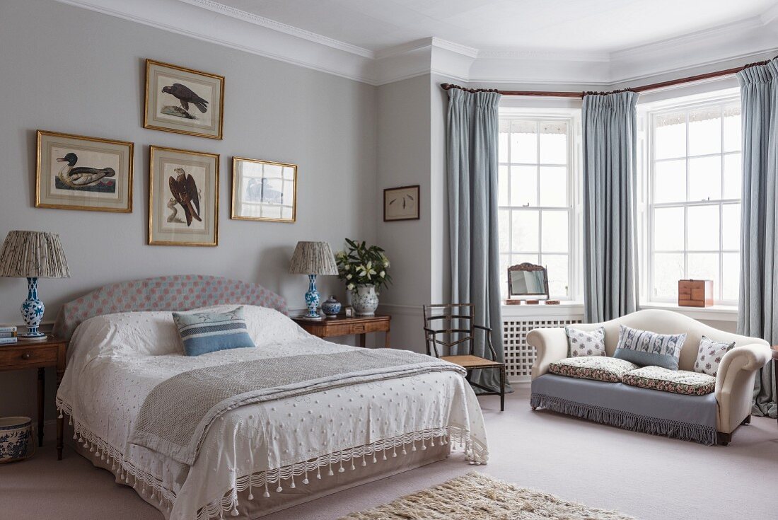 Elegant bedroom with sofa in window bay
