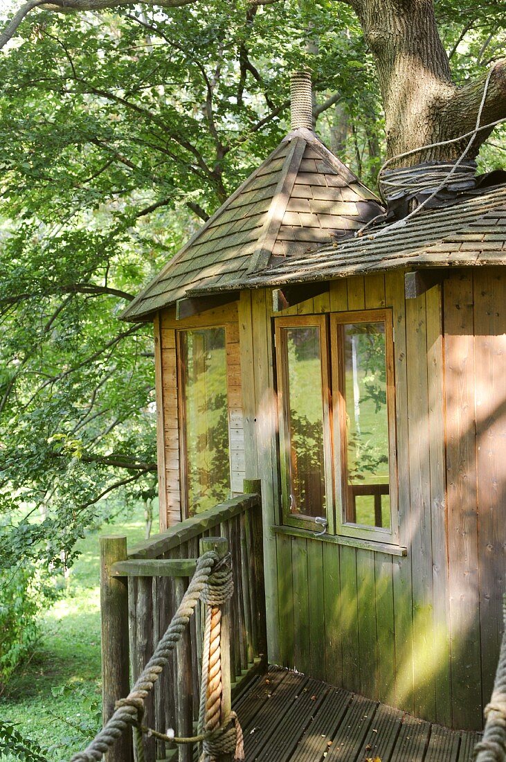 Rustikales Baumhaus mit Holzsteg und Schindeldach