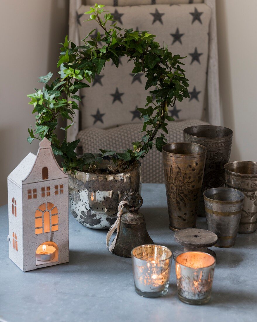 Festive arrangement of ivy wreath, house-shaped lantern and tealight holders