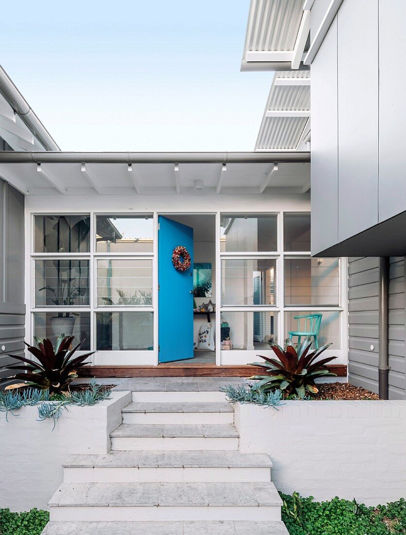 Treppe zum Architektenhaus mit Glasfront und blauer Haustür