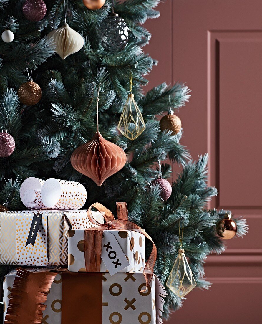 Verpackte Geschenke vordem Weihnachtsbaum in Metallicfarben