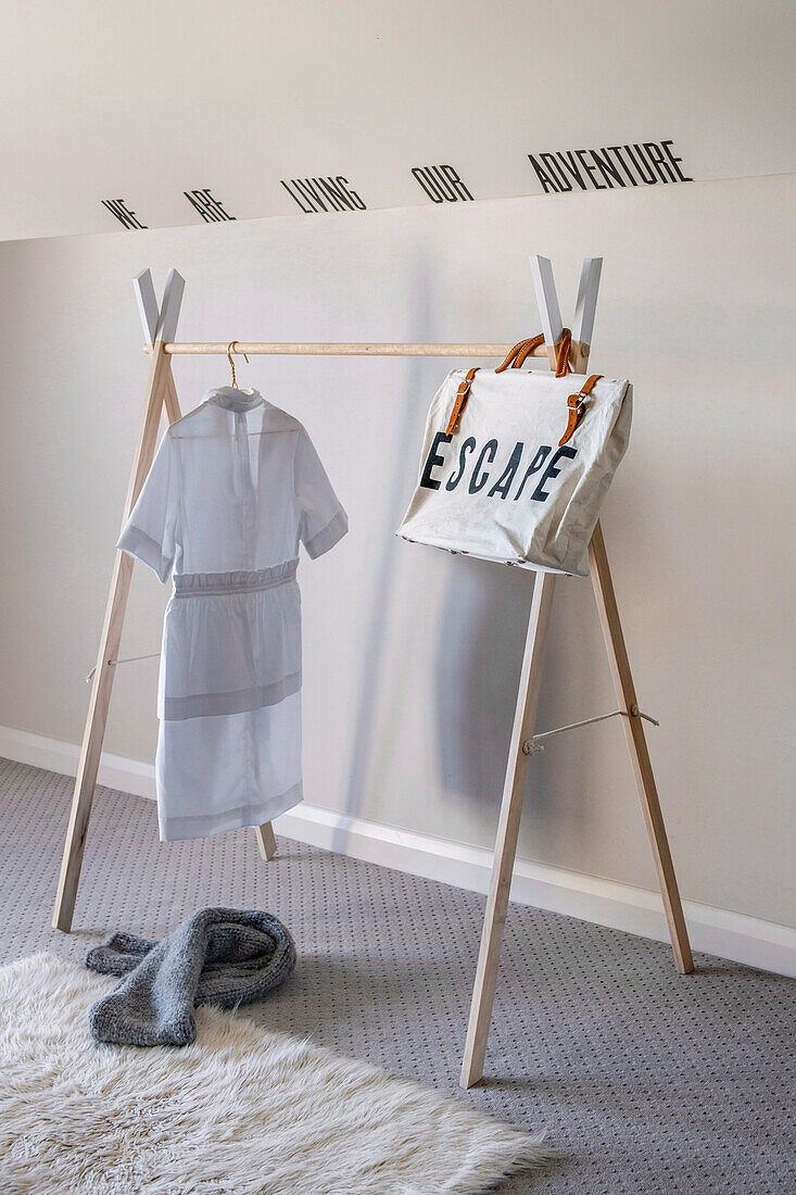 Wooden clothes rack with dress and printed fabric bag