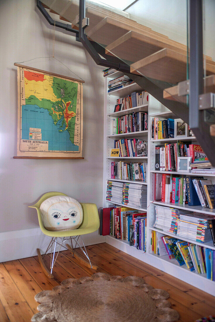 Reading corner under staircase, vintage wall map and bookshelf