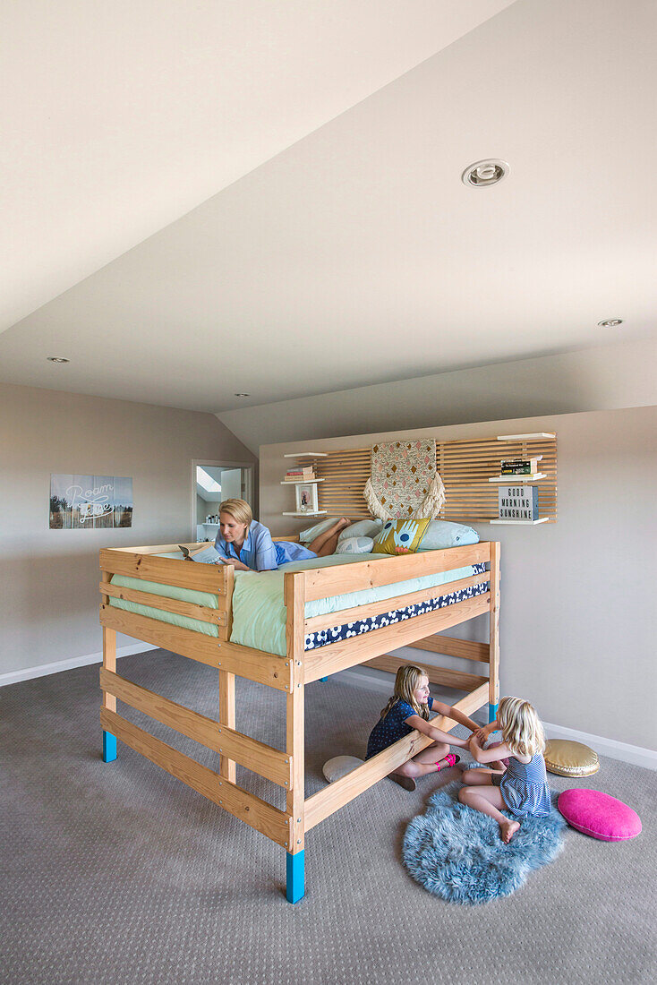 Wooden loft bed in children's room with children and mom