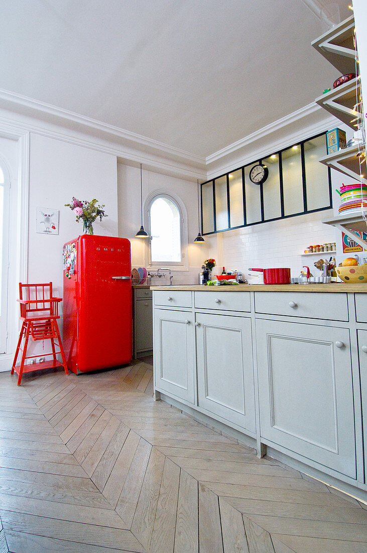 Graue Unterschränke und roter Kühlschrank in Altbau-Wohnung