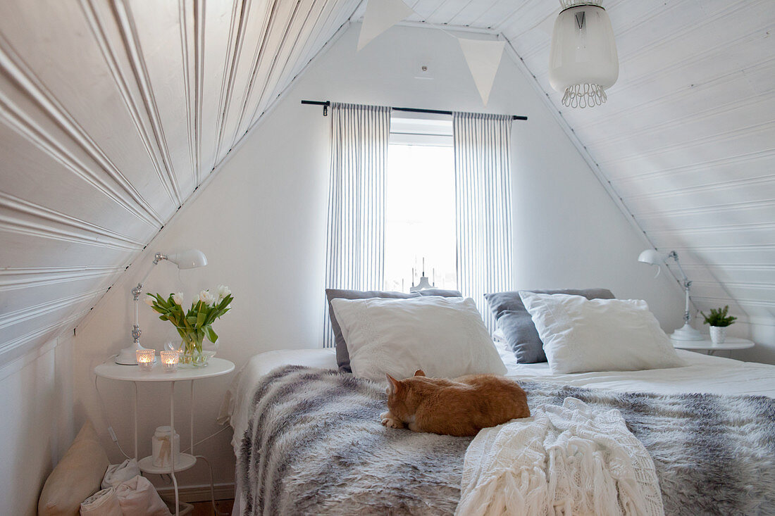 Cosy white bedroom with gable ceiling