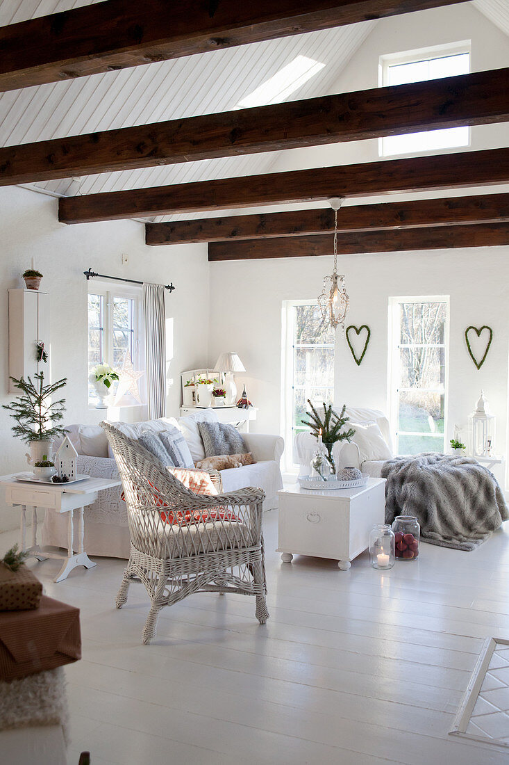 White living room decorated for Christmas with exposed roof structure