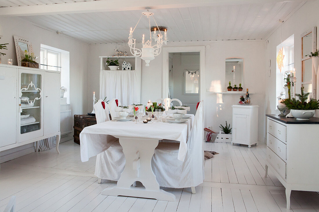 Set table in dining room decorated entirely in white