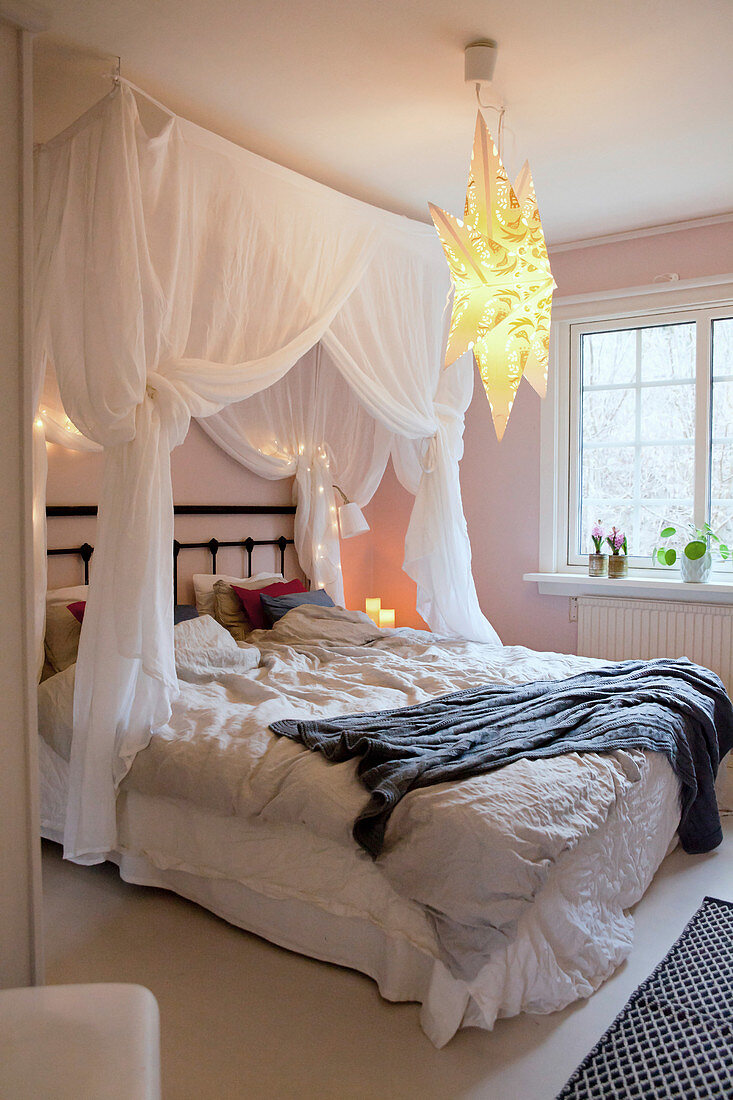 Romantischer Betthimmel über dem Bett mit zerknitterter Bettwäsche