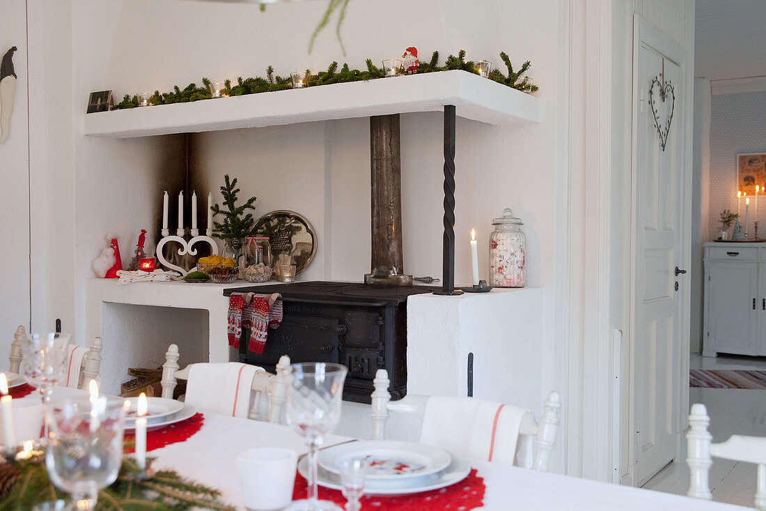 View across dining table to festively decorated wood-fired kitchen cooker