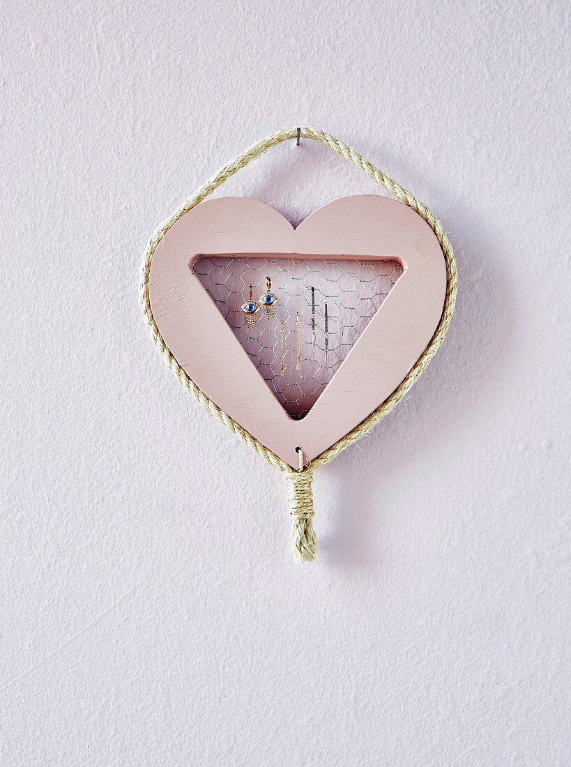 Homemade jewelry holder in the shape of a heart on the wall