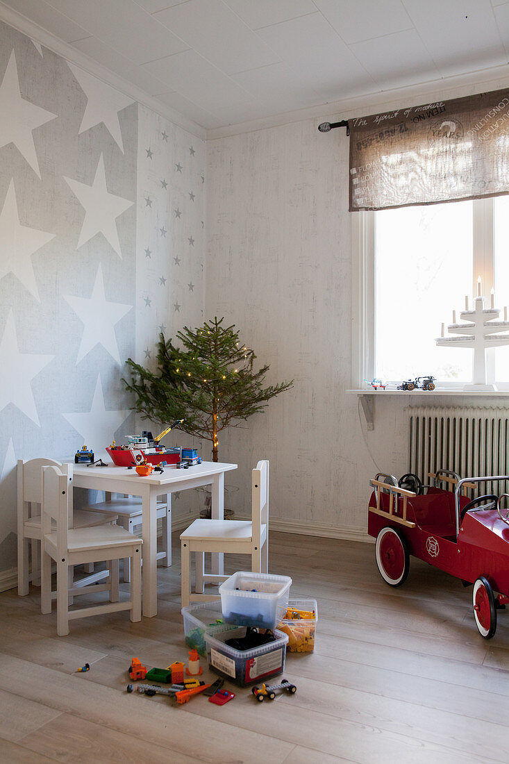 Kindertisch und Stühle im Kinderzimmer mit kleinem Weihnachtsbaum