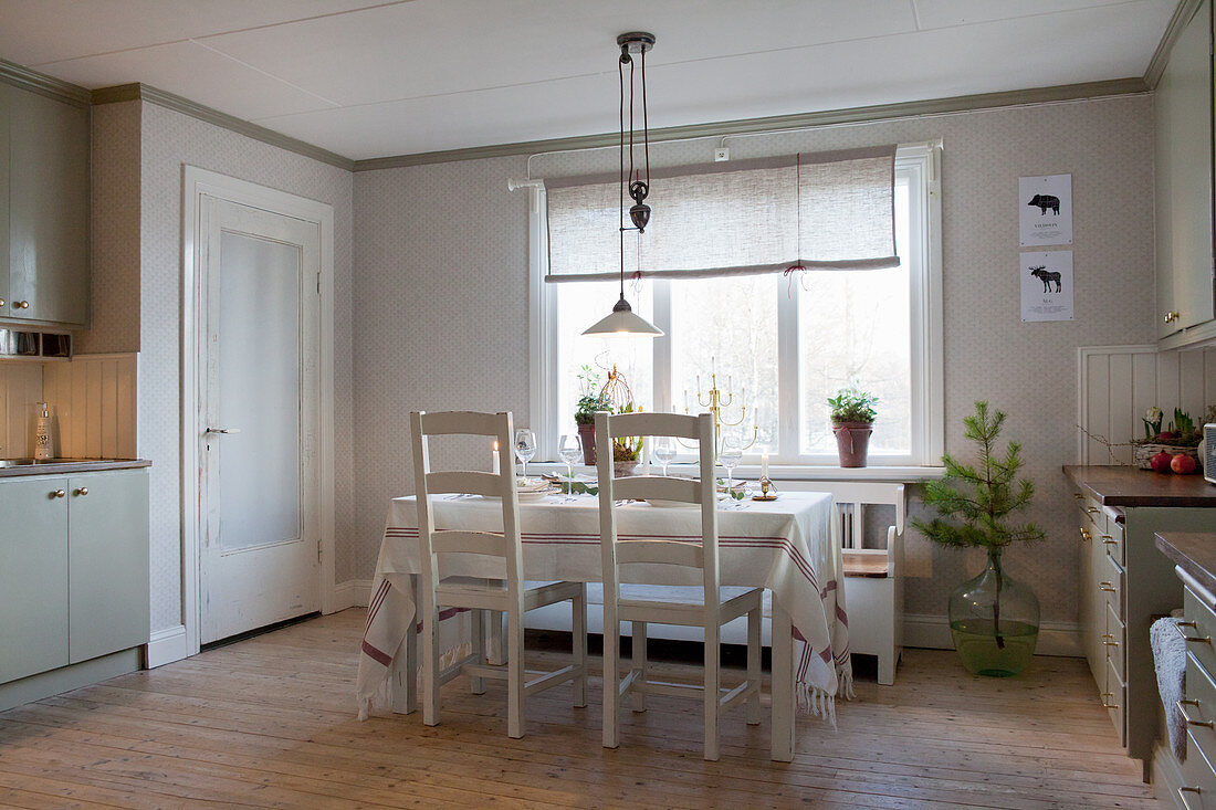 Dining table in cream kitchen-dining room in country-house style