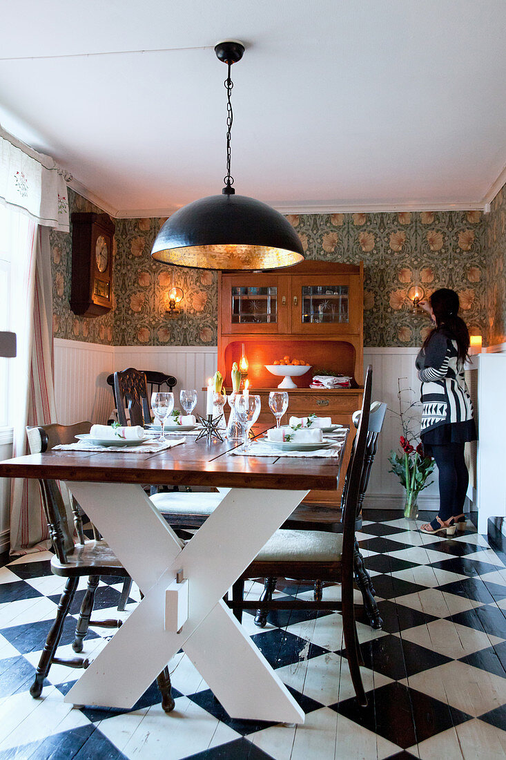 Rustic table in dining room with chequered floor and vintage-style wallpaper