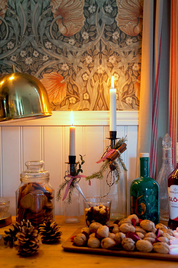 Christmas arrangement of candles in bottles, nuts and biscuits