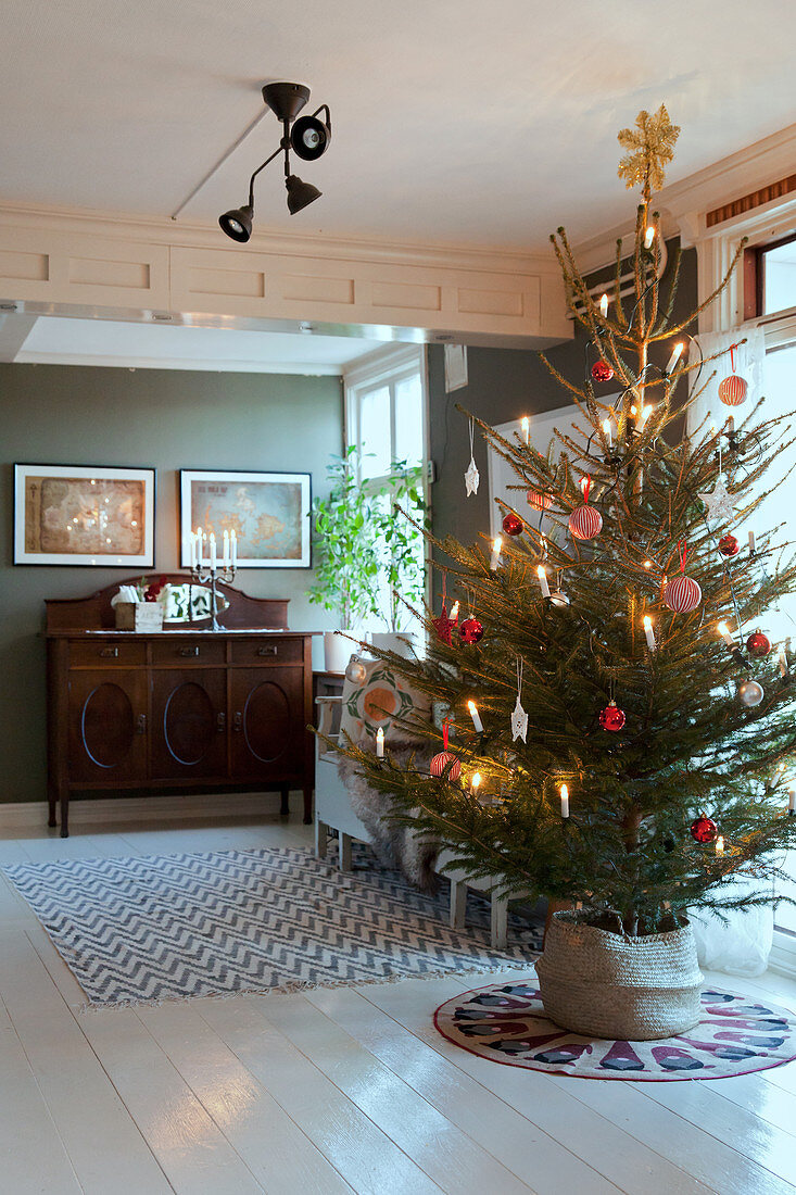 Schlicht geschmückter Weihnachtsbaum im klassischen Wohnzimmer