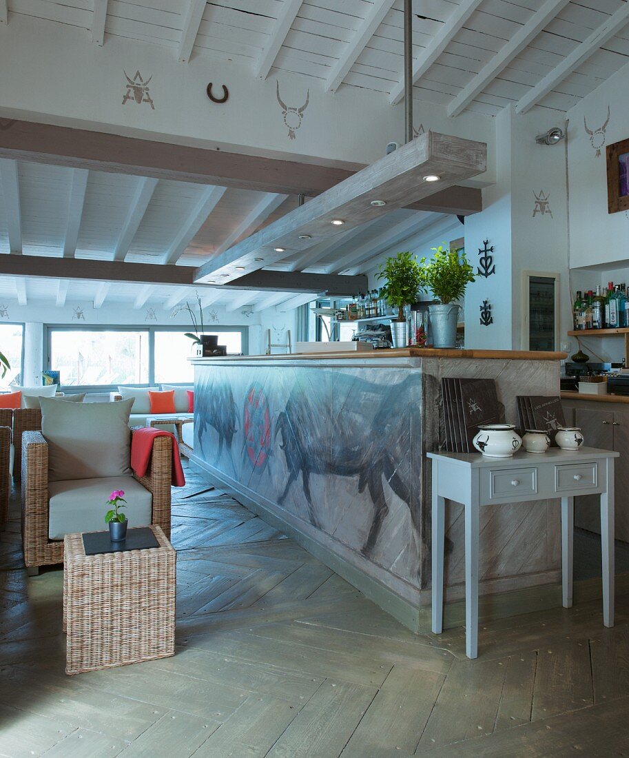 Bulls painted on front of kitchen counter below rustic wood-beamed ceiling